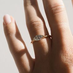 a woman's hand with a diamond ring on top of her finger and the other hand holding an engagement ring