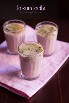 three glasses filled with food sitting on top of a pink napkin next to each other