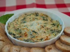 spinach dip in a white bowl surrounded by crackers