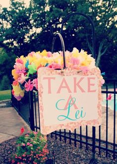 there is a sign that says take a lie next to a fence with flowers on it