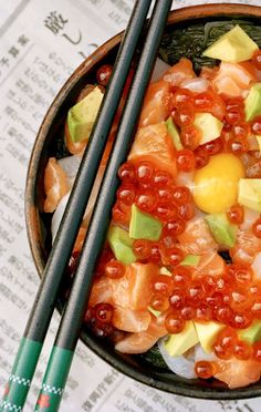 two chopsticks sit on top of a bowl of food