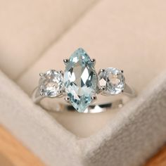 This ring features a 6*12mm marquise cut aquamarine and sterling silver finished with rhodium. Customization is available. It is made by hand, and it will take about 7 days to finish the ring after your payment is completed. Main stone: Natural aquamarine Aquamarine weight: Approx 1.50 ct Metal type: sterling silver finished with rhodium Accent stone: cz Customization is available, I also can make it with 14k solid gold (white or yellow or rosee, just feel free to contact me. Any question, just Aquamarine Ring Engagement, Aquamarine Wedding Ring, Engagement Ring Three Stone, Diamond Alternative Engagement Ring, Rose Gold Moissanite Ring, March Birthstone Ring, Healing Crystal Ring, Herkimer Diamond Ring, Ring Three Stone