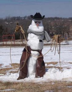 a snowman is standing in the middle of a field with a harness on it's back