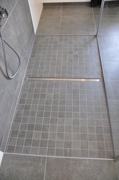 a bathroom with a shower and tiled floor