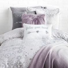 a bed covered in pillows and blankets with the words follow your heart written on it