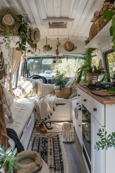 the interior of a camper with plants and rugs on the floor in front of it