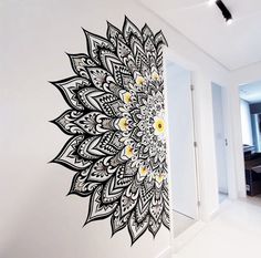 a large black and white flower on the wall next to a doorway with an open door