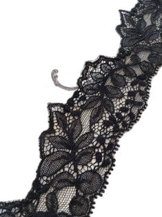 black lace garter with metal hook on white background