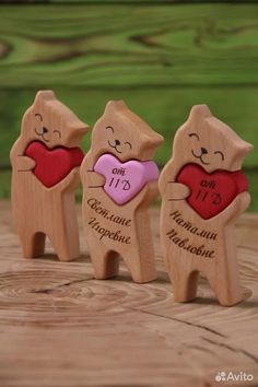 three small wooden bears holding a heart