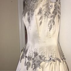 a white dress with silver beading on it