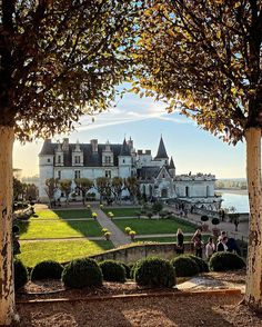 people are walking around in front of a castle