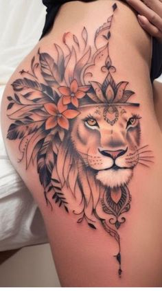 a woman's thigh with a lion tattoo and flowers on her head, as well as an arrow