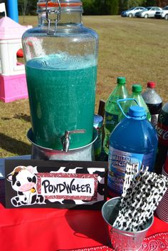 a table topped with bottles and cups filled with liquid next to an ice cream maker