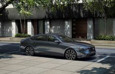 a silver car is parked on the side of the road in front of a building