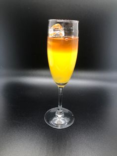 a glass filled with liquid sitting on top of a table next to an orange slice