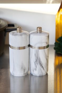 two marble salt and pepper shakers sitting on a counter