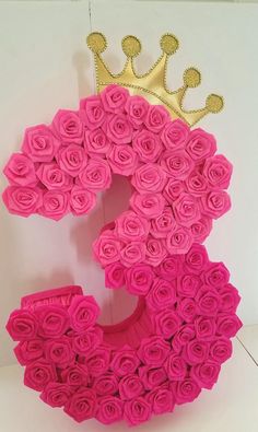 the letter e is made out of pink roses with a gold crown on top of it