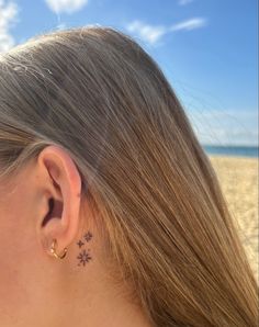 a close up of a person's ear with a small tattoo on the back of their left ear