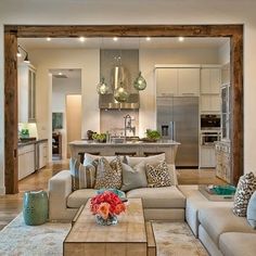 a living room filled with furniture and a kitchen in the backgroung area