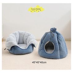 two blue pet beds sitting next to each other on the floor in front of a white wall