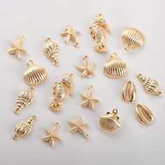 gold plated charms with sea animals and shells on white background, including one in the middle