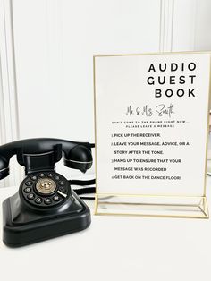 an old - fashioned telephone sits next to a sign that says audio guest book and the phone has been placed in front of it