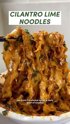 a bowl filled with pasta covered in sauce and garnished with parsley