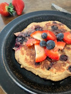 a pancake with strawberries and blueberries on it