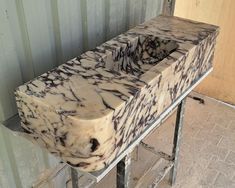 two marble sinks sitting on top of a metal rack in front of a building wall