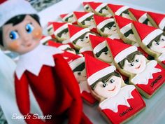 an elf is sitting next to some cookies