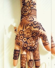 a henna tattoo is shown on the palm of someone's hand with flowers