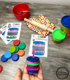 a person is holding a piece of cake in front of some play dough and cupcakes