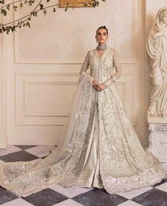 Detailed florals bloom in moonlit tendrils on the dreamy ivory organza canvas of Un Pavot, luxuriously laden with iridescent sequin, sparkling crystal and oyester pearls with dabka work creating an ethereal impact. Paired with an ivory organza foil print dupatta emblazoned with filigreed bootis, elaborately detailed borders and dramatically accented pants, this look is reminiscent of royal regalia and a perfect choice for any and all formal occasions. Party Dress Indian, Pakistani Mehndi Dress, Embroidery Clothes, Mehndi Dresses, Mehndi Dress, Eid Party, Pakistani Wedding Dresses, Stylish Party, Indian Embroidery