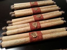 six wine corks are lined up in a row on a black table top with red and gold ribbon