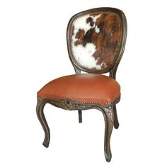 an antique chair with cow hide upholstered on the back