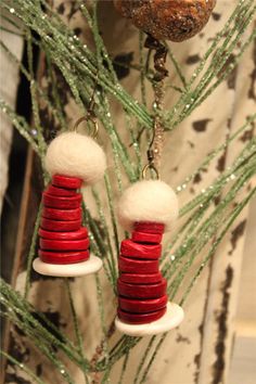 two red and white christmas decorations hanging from a tree