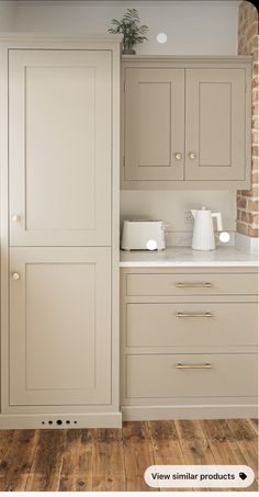 an image of a kitchen setting with white cabinets and wood flooring in the background