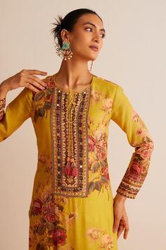 Yellow straight kurta with floral print, highlighted with mirror work and tassels. Paired with a churidar and dupatta.
Components: 3
Pattern: Print
Type Of Work: Floral
Neckline: Round Neck
Sleeve Type: Full Sleeves
Fabric: Cotton Silk
Color: Yellow
Other Details: 
Model height:  5 ft 9 inches, wearing size S
Length:
Kurta Length - 46 inches
Churidar Length - 55 inches
Floral print dupatta with tassels
Occasion: Puja - Aza Fashions Bohemian Floral Print Traditional Wear For Navratri, Bohemian Traditional Wear With Floral Print For Festive Occasions, Bohemian Floral Print Traditional Wear For Festive Occasions, Unstitched Bohemian Traditional Wear With Floral Print, Bohemian Chanderi Traditional Wear With Floral Print, Bohemian Semi-stitched Traditional Wear With Floral Print, Elegant Floral Print Kurta For Festive Season, Elegant Floral Print Sharara For Festivals, Festive Floral Print Sets For Transitional Seasons