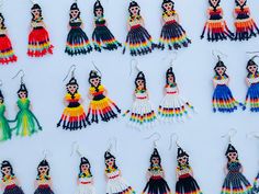 a collection of beaded mexican style earrings on display in front of a white background