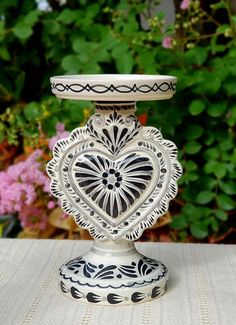 a white and black vase sitting on top of a table