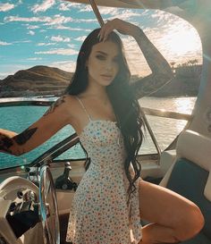 a woman in a white dress posing on a boat