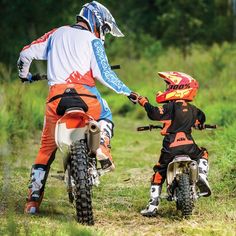 a person on a dirt bike and a child on a motorbike in the grass