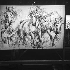 three horses running in the same direction on a large piece of art that is hanging up