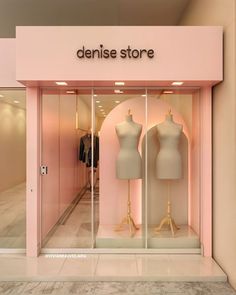 a pink store front with mannequins in the window and clothes on display