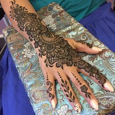 a woman's hand with henna tattoos on it