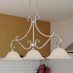 three light chandelier hanging from the ceiling in a kitchen