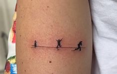 a person with a small tattoo on their arm is walking across the line between two people