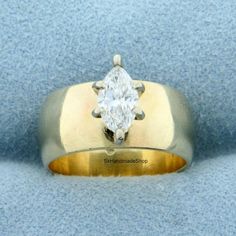 a yellow and white gold ring with a diamond in the center on a blue background