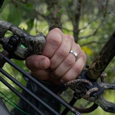 a man holding onto the handle of a bow with an eyeball in his hand