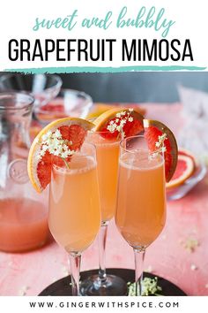 two glasses filled with grapefruit mimosa sitting on top of a table